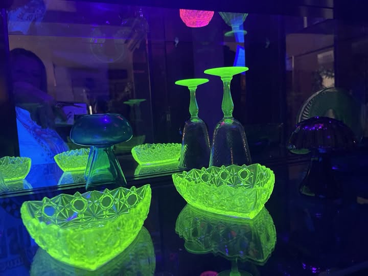 Uranium glass custard compote featuring a decorative love doves motif, displayed on a pedestal base, with opaque yellow glass typical of custard-style uranium glass.